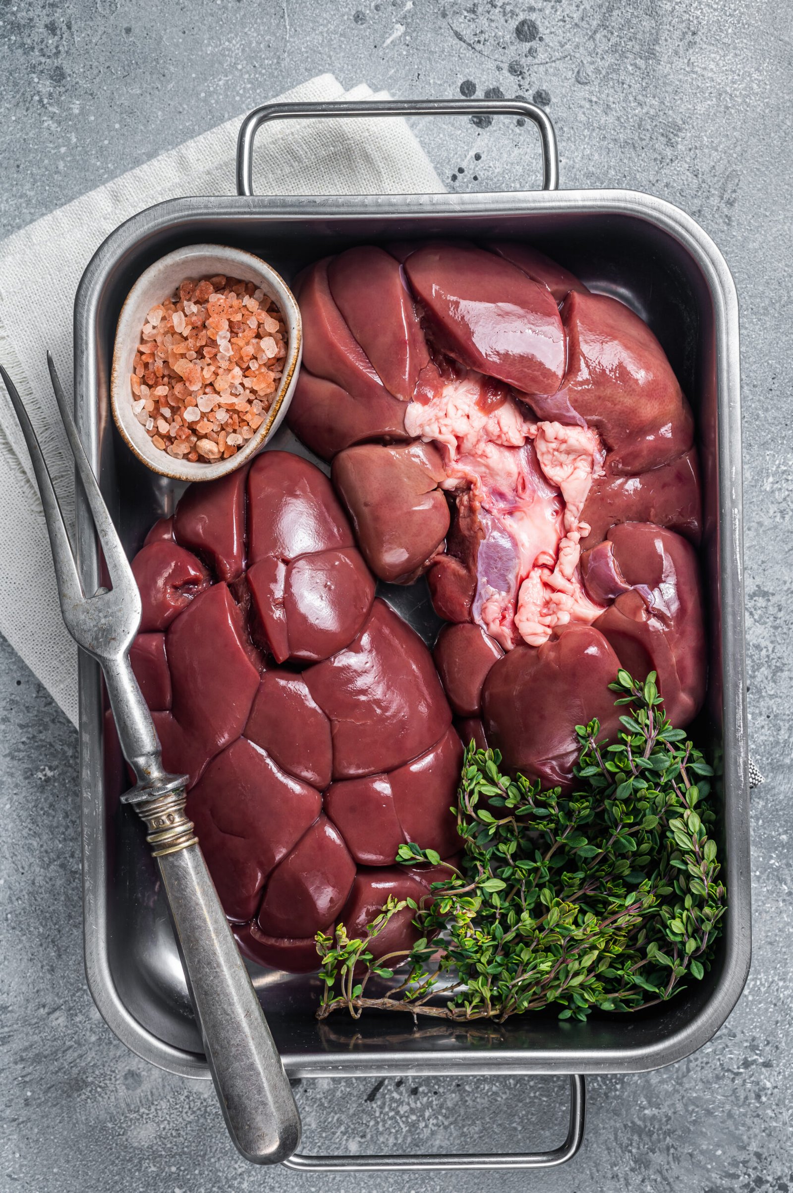 Fresh Raw Beef veal kidney in kitchen tray. Gray background. Top view.